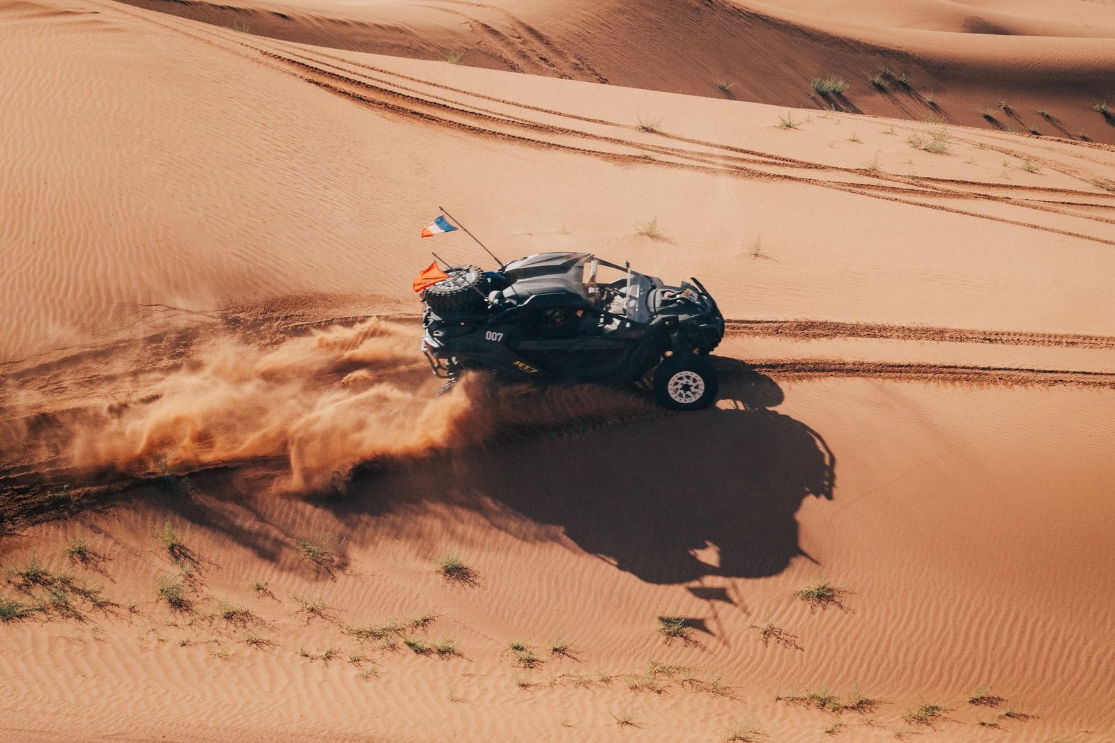 SSV Can-Am n°007 soulevant une gerbe de sable dans les dunes, vue aérienne par drone, Raid Can-Am Spirit 2026 au Maroc